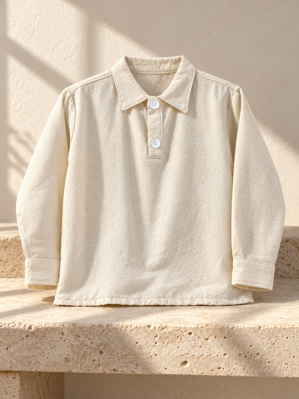Camisa de niño de manta con cuello y dos botones: ambiente editorial (imagen ilustrativa creada con IA)
