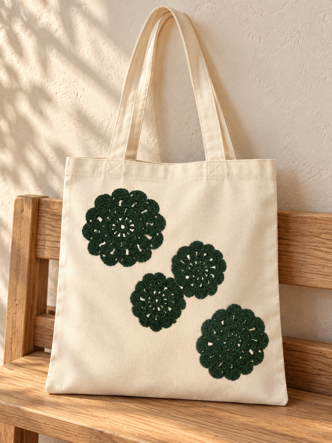 Bolsa de manta con rosetas tejidas verde bosque: ambiente editorial (imagen ilustrativa creada con IA)